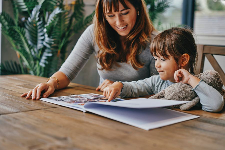 Mother and child happily reading a photo book