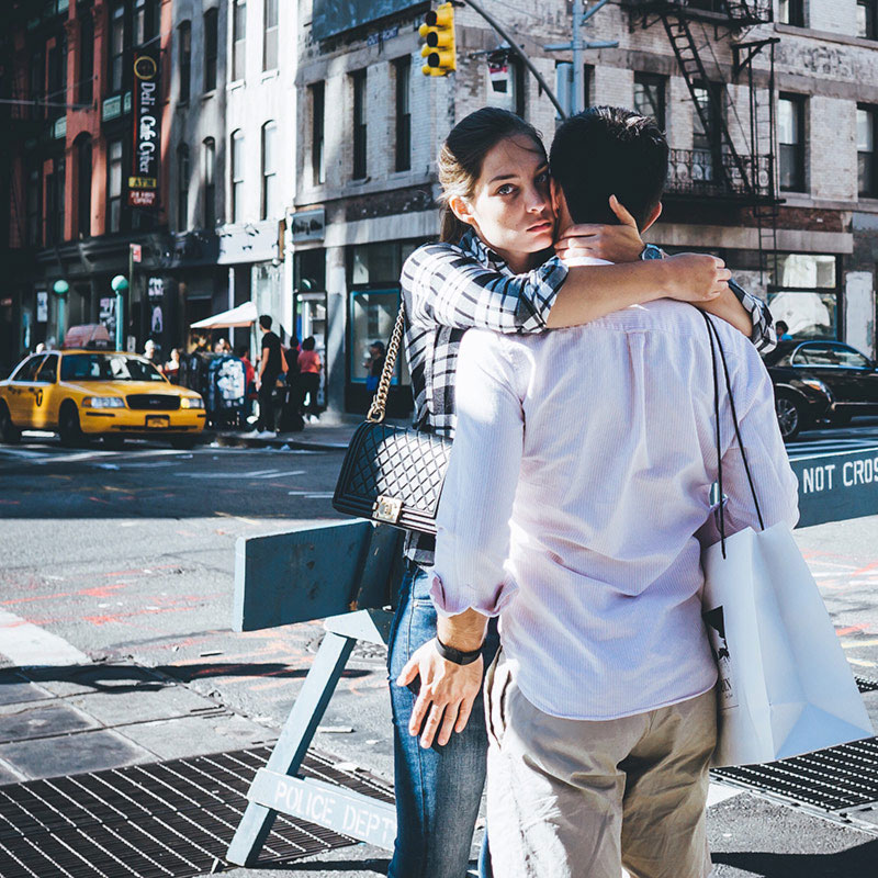 Image represents iphone photography tip Include People In Your Photos. A man and a woman are hugging in a city.